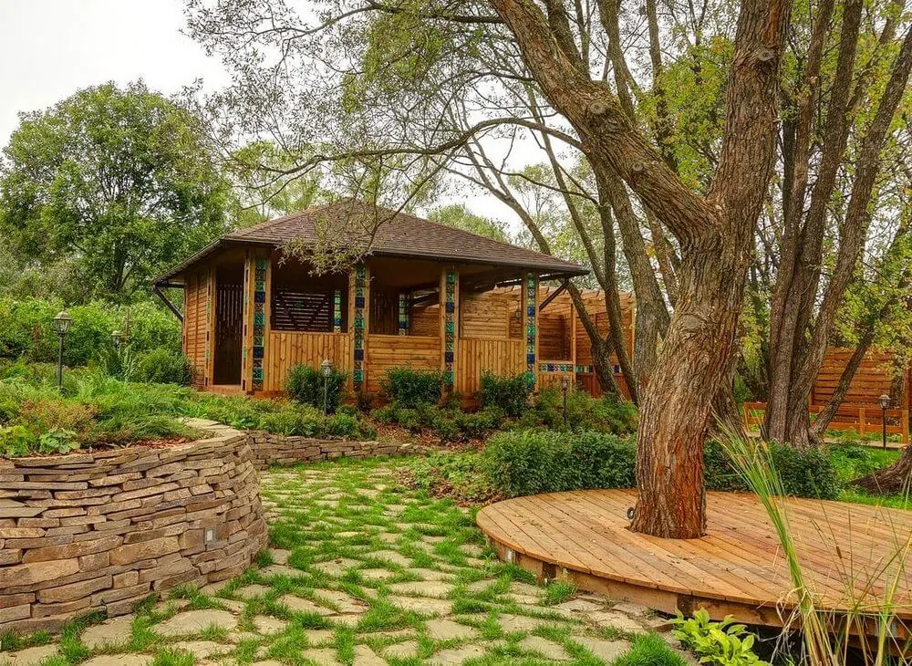 Нестандартный участок с качелями, беседкой и круглым мостом через ручей