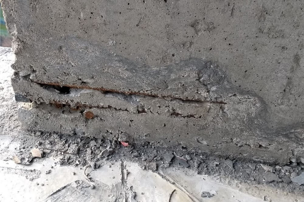 Фото 1. Участок недовибрированного бетона, с оголением и коррозией арматуры железобетонной стенки.